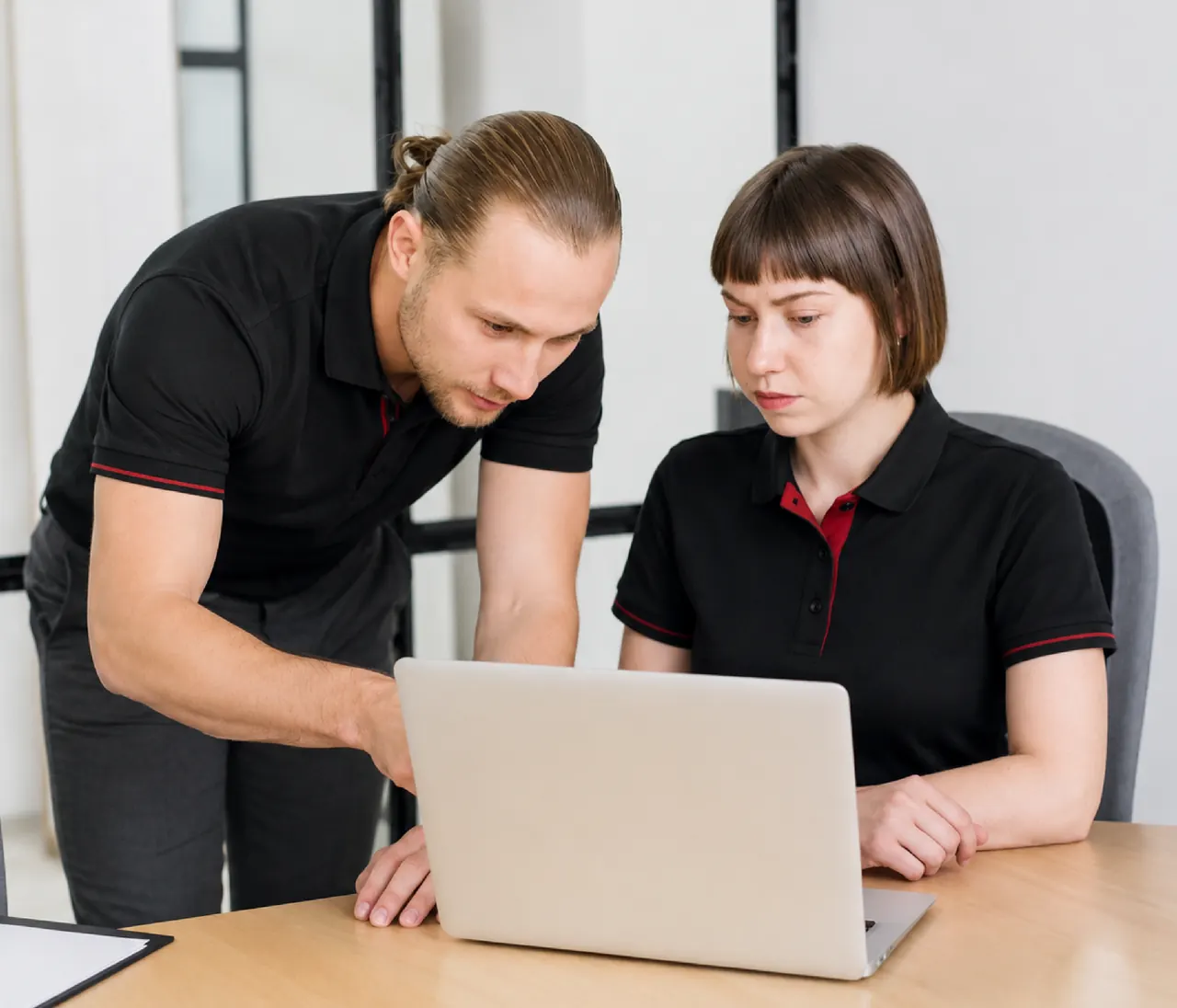 Two consultants reviewing risk findings together on a laptop